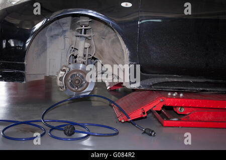 Les pneus de voiture étant supprimée et remplacée en service de garage. Banque D'Images