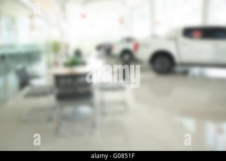 L'intérieur de floue car showroom avec des chaises et des voitures pour l'arrière plan. Banque D'Images