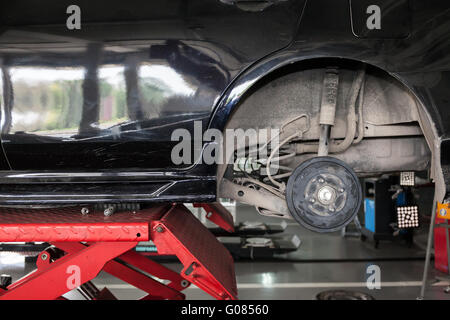 Les pneus de voiture étant supprimée et remplacée en service de garage. Banque D'Images