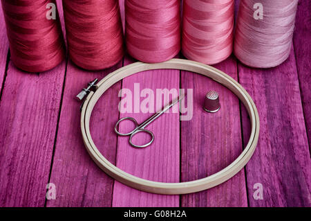 Hoop avec les threads pour la couture et broderie sur la vieille table en bois, ton violet, retro Banque D'Images