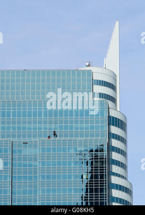 Les hommes en suspension dans les faisceaux sur le côté d'un gratte-ciel (Exchange Place Centre) nettoyage windows dans Paulus Hook, Jersey City Banque D'Images