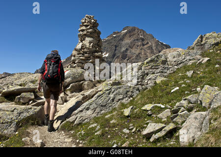 Randonneur à un cairn sur le sentier de randonnée, Valais Banque D'Images