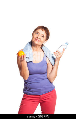 Jolie femme de 50 ans avec une orange et une bouteille d'eau Banque D'Images