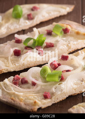 Tarte Flambée à l'oignon et le jambon sur un plateau en bois Banque D'Images