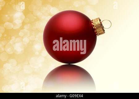 Gros plan d'une boule de noël rouge avec fond jaune floue Banque D'Images