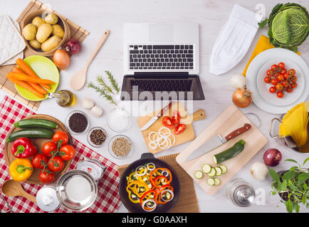 Accueil table de cuisine Vue supérieure avec ordinateur portable, d'ingrédients alimentaires, des légumes crus, des ustensiles de cuisine et ustensiles, vue d'en haut Banque D'Images