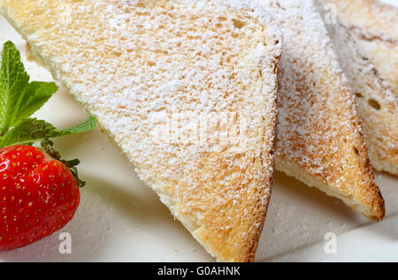 Toasts avec du sucre en poudre et de la confiture de fraise Banque D'Images