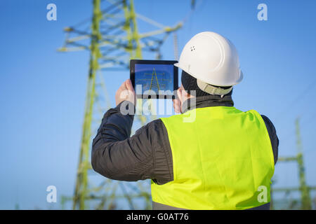 Ingénieur électrique avec près de Tablet PC, haute tension Banque D'Images