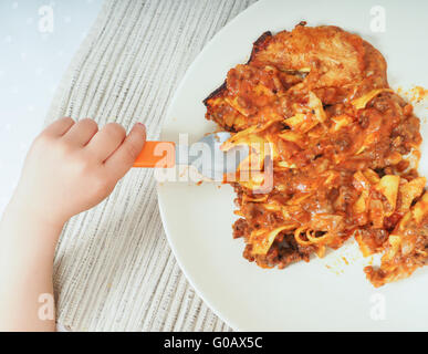 Enfant de manger des lasagnes Banque D'Images