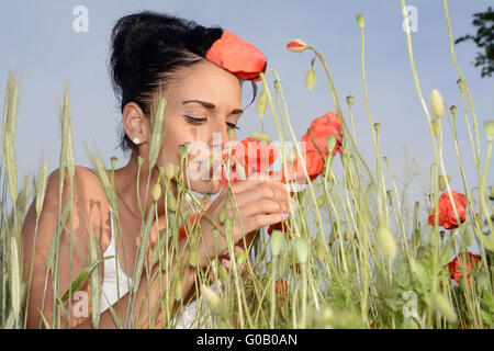 Woman smelling poppy Banque D'Images