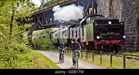 Deux cyclistes avec locomotive à vapeur, Witten, Allemagne Banque D'Images