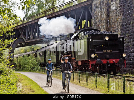 Deux cyclistes avec locomotive à vapeur, Witten, Allemagne Banque D'Images