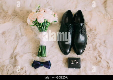 Matin du marié. Accessoires de mariage. Papillon Bleu-cravate, boutons de manchettes, bagues et bouquet de roses blanches Banque D'Images