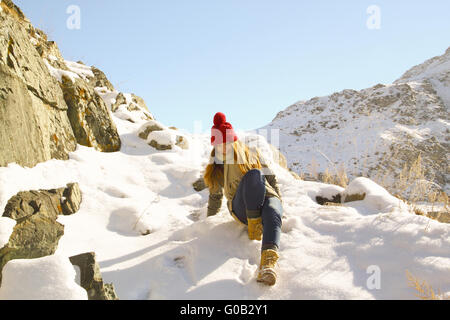 Jeune fille tombe en panne avec une montagne de neige Banque D'Images