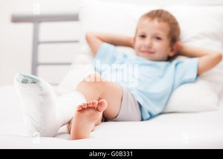 Petit enfant garçon avec bandage en plâtre sur le talon de la jambe Banque D'Images