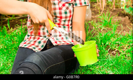 À l'aide de mains de Femme Libre outil de jardinage sol remplissage vert en pot de fleurs Banque D'Images
