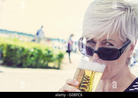 L'un des hauts Femme buvant un verre de bière Banque D'Images