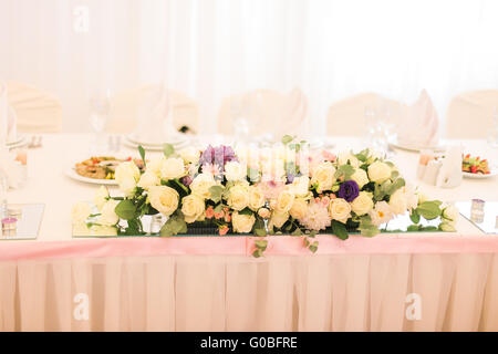 Élégamment décorées avec des fleurs blanches, des verres et des bougies de mariage pour célébrer restaurant Banque D'Images