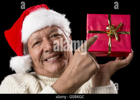 Senior masculin Pointing at Red Wrapped Christmas Gift Banque D'Images