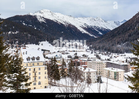 Belle vue de Davos en hiver avec des toits couverts de neige et les Alpes, Canton des Grisons, Suisse. Banque D'Images