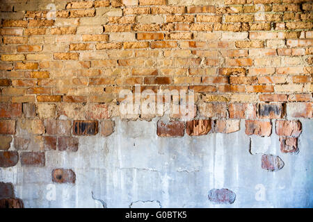 Vieux mur de briques avec le plâtre endommagé Banque D'Images