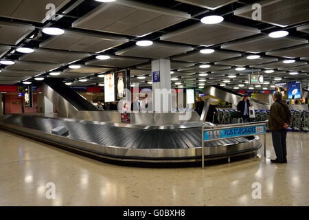 Récupération des bagages de l'aéroport attendant son homme carrousel sac, l'aéroport de Genève Banque D'Images