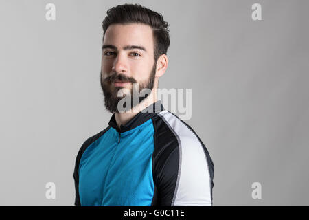 Portrait du cycliste barbu portant des jersey avec copyspace looking at camera sur fond gris studio Banque D'Images