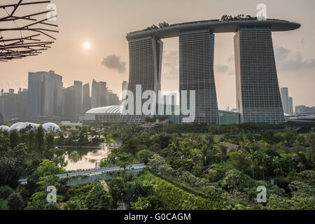 Vue de la Marina Bay Sands Hotel au coucher du soleil à partir de la passerelle surélevée Supertree dans des jardins par le Bay, Singapour Banque D'Images