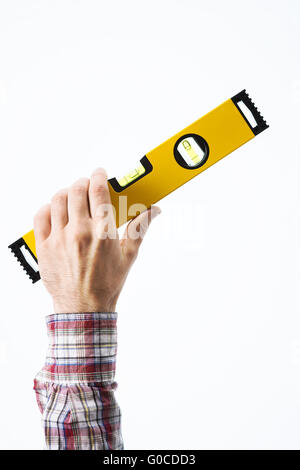 Male carpenter's hand holding a niveau jaune sur fond blanc Banque D'Images