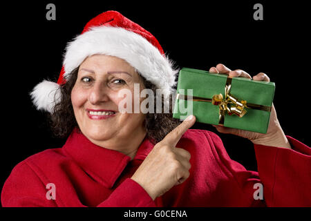 Smiling Mature Woman Pointing at enveloppé cadeau de Noël Banque D'Images