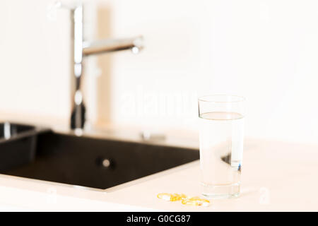 Comprimés et verre de l'eau sur l'horizontale de comptoir Banque D'Images