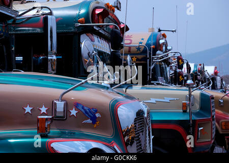 Le fameux chicken buses qui est un nom anglais pour un familier, colorés et décorés de modification bus dans la gare routière d'Antigua une ville dans les hauts plateaux du Guatemala Amérique Centrale Banque D'Images