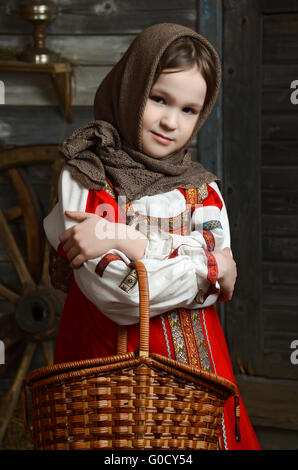 Belle jeune fille en costume russe assis dans un intérieur traditionnel Banque D'Images