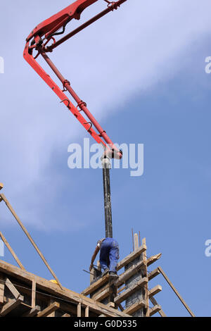 Builder travailleur avec tuyau de la pompe à béton montés sur camion Banque D'Images