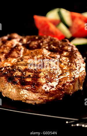 Le steak grillé et légumes sur verticale de la plaque noire Banque D'Images