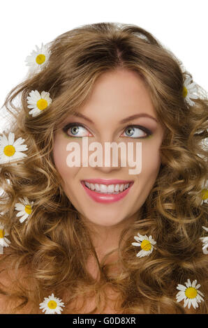 Jeune femme avec des pâquerettes dans les cheveux bouclés regarde ailleurs Banque D'Images