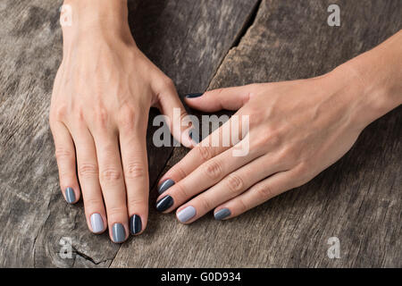 De belles mains avec la miniature peinte dans une couleur gris Banque D'Images