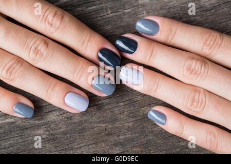 De belles mains avec la miniature peinte dans une couleur gris Banque D'Images