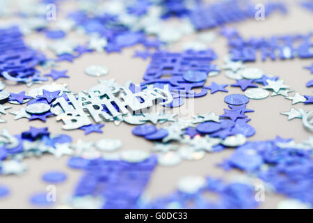 Joyeux anniversaire confetti bleu pièces - macro photo Banque D'Images