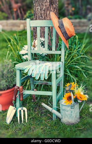 Image vie encore d'outils de jardin et plantes reposant sur une vieille chaise de jardin rustique Banque D'Images