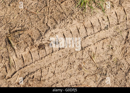 La texture. trail des pneus sur le sable craquelé la couverture du sol. Banque D'Images