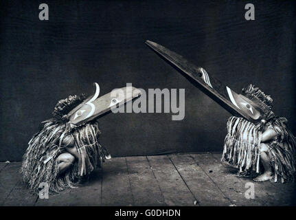 Native American Nakoaktok danseurs portant des masques de l'Kotsuis mythiques oiseaux pendant un potlatch traditionnel 1914 en Colombie-Britannique, Canada. Le Kotsuis Hohhuq et représentent des costumes, serviteurs de l'homme Pahpaqalanohsiwi-eating monster. Les mandibules de ces énormes masques en bois sont contrôlés par des chaînes. Banque D'Images