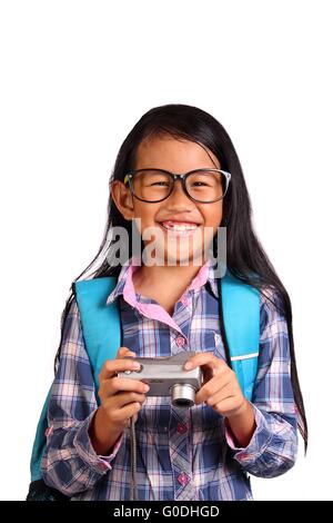 Little girl smiling while tout en tenant son appareil photo isolated on white Banque D'Images