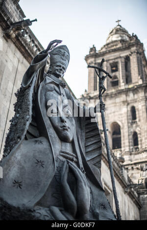 Statue du pape Jean-Paul II Cathédrale métropolitaine de Mexico // MEXICO, Mexique — Une statue en bronze du pape Jean-Paul II se dresse devant l'entrée ouest de la Cathédrale métropolitaine de Mexico. La statue, officiellement intitulée Llaves de Fe (clés de la foi), a été créée par le sculpteur mexicain Francisco Cárdenas Martínez et dévoilée en 2007 pour commémorer le 30e anniversaire de la première visite du Pape au Mexique en 1979. La sculpture de 3,1 mètres de haut incorpore des clés données par plus de 7 millions de citoyens mexicains, qui ont été fondues et intégrées dans la fonte de bronze. Construit BE Banque D'Images