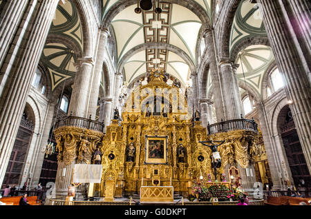 Cathédrale métropolitaine d'Altar Del Perdón Mexico // MEXICO, Mexique — L'autel del Perdón (autel du pardon) présente une architecture baroque churrigueresque au sein de la cathédrale métropolitaine de Mexico. Conçu par l'architecte espagnol Jerónimo de Balbás et achevé en 1735, le retablo doré de 12 mètres de haut présente des colonnes estípite et une peinture centrale de la Vierge du pardon. Historiquement, l'autel a servi de site pour l'absolution finale des criminels condamnés et des masses pénitentielles. Gravement endommagé dans un incendie de 1967, l'autel a subi une restauration importante impliquant des feuilles d'or Banque D'Images