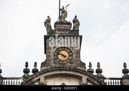 Cathédrale métropolitaine de Mexico statues de la tour de l'horloge Mexico // MEXICO CITY, MEXICO — trois statues représentant les vertus théologiques de la foi, de l'espoir et de la Charité couronnent la tour de l'horloge sur la façade sud principale de la cathédrale métropolitaine de Mexico. Ces sculptures néoclassiques ont été ajoutées lors des modifications apportées par Manuel Tolsá à la cathédrale au début du XIXe siècle, achevées vers 1813. La foi est généralement représentée les yeux bandés, représentant la confiance sans vue, tandis que la Charité porte une flamme symbolisant l'amour divin, et l'espérance porte une ancre représentant la fermeté spirituelle. Le métro Banque D'Images