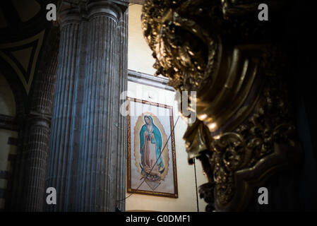 Peinture de notre-Dame de Guadalupe Cathédrale métropolitaine de Mexico // MEXICO CITY, Mexique — peinture de notre-Dame de Guadalupe exposée dans une chapelle de la Cathédrale métropolitaine de l'Assomption de la très Sainte Vierge Marie au ciel. La cathédrale métropolitaine, construite par étapes de 1573 à 1813, est la plus grande cathédrale des Amériques et sert de siège à l'archidiocèse primat de Mexico. La cathédrale dispose de 16 chapelles latérales, y compris des espaces dédiés à la dévotion à notre-Dame de Guadalupe, la sainte patronne du Mexique. Construit sur le site de l'ancien Templo Mayor aztèque, th Banque D'Images