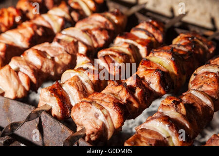 Des brochettes avec des oignons. Tranches de viande juteuse en préparation dans la chaleur. De délicieux repas juteux Banque D'Images