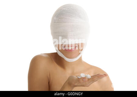 Femme avec la tête bandée avec les tablettes sur palm Banque D'Images