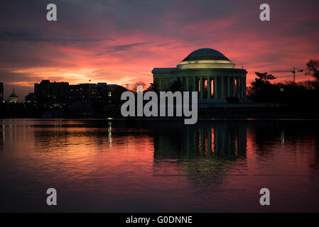 Jefferson Memorial Silhouette Sunrise Washington DC // WASHINGTON DC — le Jefferson Memorial est dessiné sur un ciel orange vif avant l'aube dans cette vue du côté ouest du monument. La statue de Thomas Jefferson se tient bien en évidence au centre du cadre, créant une silhouette spectaculaire dans la structure en dôme du mémorial néoclassique. Achevé en 1943, le mémorial honore le troisième président de l'Amérique et l'auteur principal de la Déclaration d'indépendance. Le mémorial, conçu par l'architecte John Russell Pope, se trouve le long du Tidal Basin dans le parc West Potomac. La teinte orange Banque D'Images